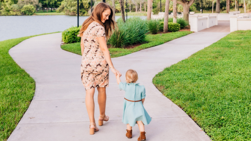 Maren and toddler daughter walking hand in hand