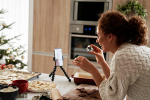 caucasian woman preparing gingerbread cookies recording video